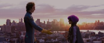 Movie still from “Kick-Ass” (2010), directed by Matthew Vaughn – A man and a woman standing next to each other on top of a building; Medium shot, Over the shoulder angle