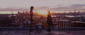 Movie still from “Kick-Ass” (2010), directed by Matthew Vaughn – A man and a woman standing next to each other on top of a building; Wide shot, Over the shoulder angle