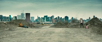 Movie still from “Kick-Ass 2” (2013), directed by Jeff Wadlow – An empty dirt field with a city in the background; Extreme Wide shot, High angle