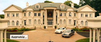 Movie still from “Kick-Ass 2” (2013), directed by Jeff Wadlow – Two cars are parked in front of a large building; Extreme Wide shot, High angle