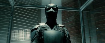 Movie still from “Kick-Ass 2” (2013), directed by Jeff Wadlow – A man in a black suit with a mask on his face; Medium shot, Low angle