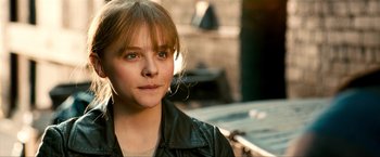 Movie still from “Kick-Ass 2” (2013), directed by Jeff Wadlow – A young woman wearing a leather jacket looking at the camera; Close Up shot, High angle