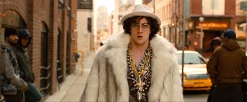 Movie still from “Kick-Ass 2” (2013), directed by Jeff Wadlow – A man in a fur coat and a hat and glasses; Medium shot, Low angle