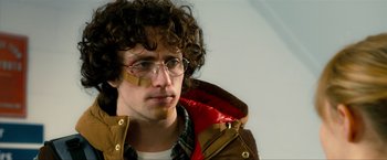 Movie still from “Kick-Ass 2” (2013), directed by Jeff Wadlow – A man wearing a red jacket and glasses; Close Up shot, Low angle