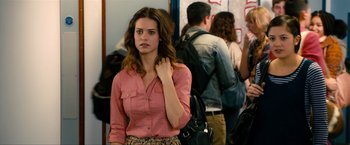 Movie still from “Kick-Ass 2” (2013), directed by Jeff Wadlow – A woman in a pink shirt and a black purse; Medium shot, Over the shoulder angle