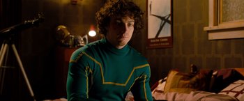 Movie still from “Kick-Ass 2” (2013), directed by Jeff Wadlow – A man with curly hair wearing a green and yellow shirt; Medium shot, Over the shoulder angle