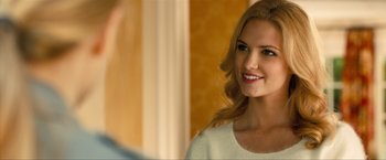 Movie still from “Kick-Ass 2” (2013), directed by Jeff Wadlow – A beautiful young lady looking into a mirror while standing in front of a mirror; Close Up shot, Over the shoulder angle