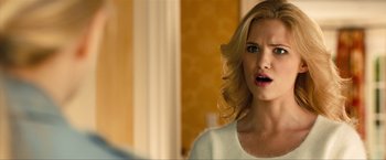 Movie still from “Kick-Ass 2” (2013), directed by Jeff Wadlow – A woman with blonde curly hair looking at a mirror; Close Up shot, Over the shoulder angle