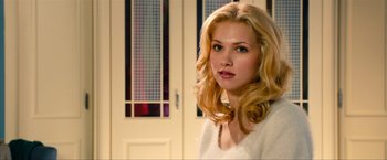 Movie still from “Kick-Ass 2” (2013), directed by Jeff Wadlow – A beautiful young blond woman in front of a door wearing a white shirt; Close Up shot, Over the shoulder angle
