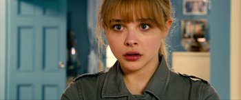 Movie still from “Kick-Ass 2” (2013), directed by Jeff Wadlow – A person with bangs looking at the camera; Close Up shot, Over the shoulder angle