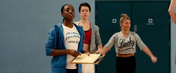 Movie still from “Kick-Ass 2” (2013), directed by Jeff Wadlow – A group of women standing in front of each other in a room; Medium shot, Over the shoulder angle