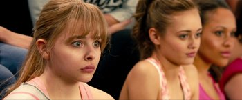 Movie still from “Kick-Ass 2” (2013), directed by Jeff Wadlow – Two young girls are looking at the camera; Close Up shot, Over the shoulder angle