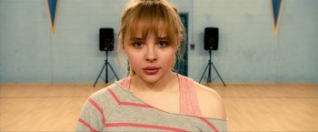 Movie still from “Kick-Ass 2” (2013), directed by Jeff Wadlow – A woman with a pink and white striped shirt; Close Up shot, Over the shoulder angle