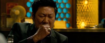 Movie still from “Kick-Ass 2” (2013), directed by Jeff Wadlow – A man in a suit and tie holding his hands to his face; Close Up shot, Low angle