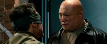 Movie still from “Kick-Ass 2” (2013), directed by Jeff Wadlow – A man in a blindfold and a man in a leather jacket; Close Up shot, Over the shoulder angle