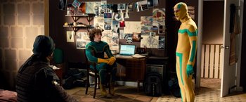 Movie still from “Kick-Ass 2” (2013), directed by Jeff Wadlow – A man sitting in front of a computer in a room; Wide shot, High angle