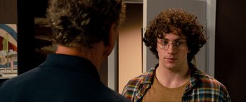 Movie still from “Kick-Ass 2” (2013), directed by Jeff Wadlow – A man with curly hair and glasses looking at himself in the mirror; Close Up shot, Over the shoulder angle