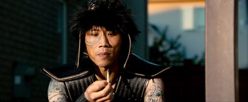 Movie still from “Kick-Ass 2” (2013), directed by Jeff Wadlow – A man in a black leather jacket holding a pipe; Close Up shot, High angle