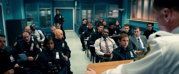 Movie still from “Kick-Ass 2” (2013), directed by Jeff Wadlow – A group of police officers sitting in a room; Medium shot, Over the shoulder angle