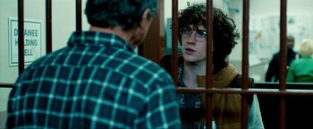 Movie still from “Kick-Ass 2” (2013), directed by Jeff Wadlow – A man in a plaid shirt is looking at another man in glasses; Medium shot, Over the shoulder angle