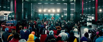 Movie still from “Kick-Ass 2” (2013), directed by Jeff Wadlow – A group of people sitting in front of an audience; Extreme Wide shot, High angle