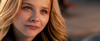 Movie still from “Kick-Ass 2” (2013), directed by Jeff Wadlow – A woman's face with brown eyes and blonde hair; Close Up shot, Over the shoulder angle