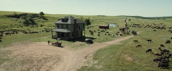 Movie still from “Killers of the Flower Moon” (2023), directed by Martin Scorsese – An aerial view of a farm house with cows in the background; Extreme Wide shot, High angle