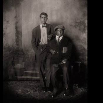 Movie still from “Killers of the Flower Moon” (2023), directed by Martin Scorsese – A couple of men in suits posing for a picture; Medium shot, Overhead angle