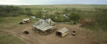 Movie still from “Killers of the Flower Moon” (2023), directed by Martin Scorsese – An aerial view of an old farm house with cattle grazing in the background; Extreme Wide shot, High angle