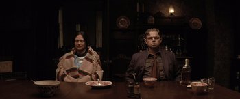 Movie still from “Killers of the Flower Moon” (2023), directed by Martin Scorsese – A man and a woman sitting at a dinner table; Medium shot, Low angle