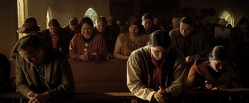 Movie still from “Killers of the Flower Moon” (2023), directed by Martin Scorsese – A group of people sitting in front of each other in a room; Wide shot, High angle