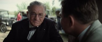 Movie still from “Killers of the Flower Moon” (2023), directed by Martin Scorsese – An older man wearing a suit and tie talking to a younger man; Close Up shot, Over the shoulder angle