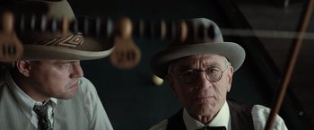 Movie still from “Killers of the Flower Moon” (2023), directed by Martin Scorsese – An older man wearing a hat and glasses; Close Up shot, Low angle
