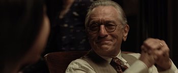 Movie still from “Killers of the Flower Moon” (2023), directed by Martin Scorsese – An older man wearing glasses sitting in a chair; Close Up shot, Over the shoulder angle