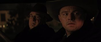 Movie still from “Killers of the Flower Moon” (2023), directed by Martin Scorsese – Two men in hats and glasses in a car; Close Up shot, Over the shoulder angle