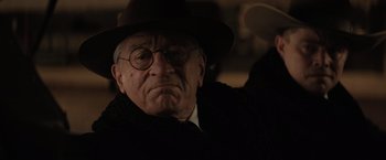 Movie still from “Killers of the Flower Moon” (2023), directed by Martin Scorsese – An old man wearing glasses and a hat; Close Up shot, Low angle