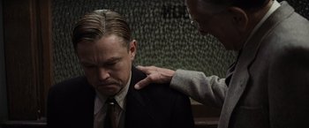 Movie still from “Killers of the Flower Moon” (2023), directed by Martin Scorsese – A man in a business suit is being comforted by another man; Close Up shot, Over the shoulder angle