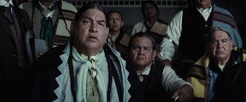 Movie still from “Killers of the Flower Moon” (2023), directed by Martin Scorsese – A group of men standing next to each other in a room; Medium shot, Over the shoulder angle