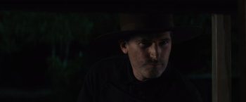 A man wearing a black shirt and a brown hat