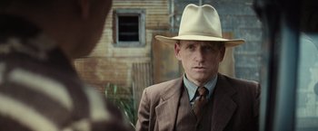 Movie still from “Killers of the Flower Moon” (2023), directed by Martin Scorsese – A man in a suit and a hat; Close Up shot, Over the shoulder angle