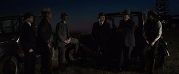 Movie still from “Killers of the Flower Moon” (2023), directed by Martin Scorsese – A group of men standing next to each other in front of an old car; Wide shot, Low angle