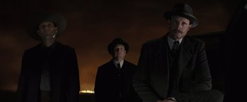 Movie still from “Killers of the Flower Moon” (2023), directed by Martin Scorsese – A group of men standing next to each other in suits; Medium shot, Low angle