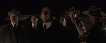 Movie still from “Killers of the Flower Moon” (2023), directed by Martin Scorsese – A group of men standing next to each other in suits; Medium shot, Low angle