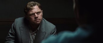 Movie still from “Killers of the Flower Moon” (2023), directed by Martin Scorsese – A person wearing a suit and tie; Close Up shot, Over the shoulder angle