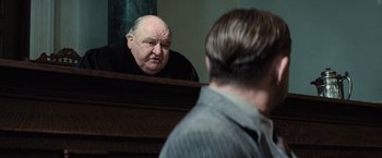 Movie still from “Killers of the Flower Moon” (2023), directed by Martin Scorsese – An older man looking at himself in the mirror; Medium shot, Over the shoulder angle