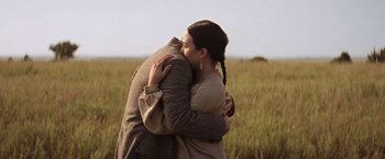 Movie still from “Killers of the Flower Moon” (2023), directed by Martin Scorsese – A man and a woman hugging in a field; Medium shot, Over the shoulder angle