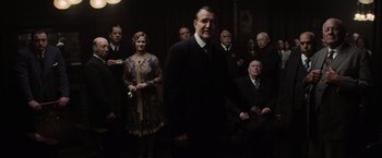 Movie still from “Killers of the Flower Moon” (2023), directed by Martin Scorsese – A group of men and women standing in a room; Medium shot, High angle