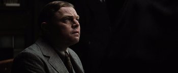 Movie still from “Killers of the Flower Moon” (2023), directed by Martin Scorsese – A person wearing a suit and tie; Close Up shot, Low angle