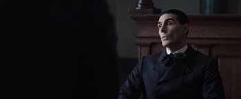 Movie still from “Killers of the Flower Moon” (2023), directed by Martin Scorsese – A man sitting in a chair wearing a suit; Close Up shot, Over the shoulder angle