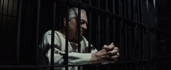 Movie still from “Killers of the Flower Moon” (2023), directed by Martin Scorsese – An old man sitting behind bars in a jail cell; Close Up shot, Low angle